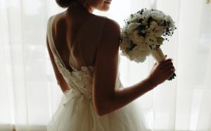 beautiful bride in a wedding dress, by window.