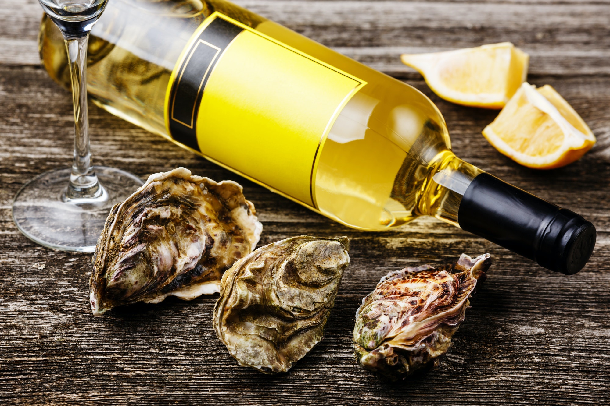 Oysters and bottle of wine on gray wooden background